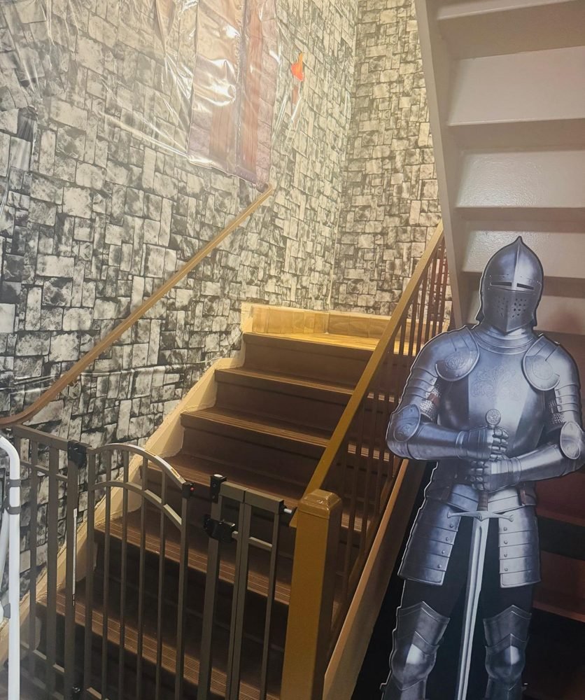 A suit of knight armor beside the castle-themed staircase at EduCastle